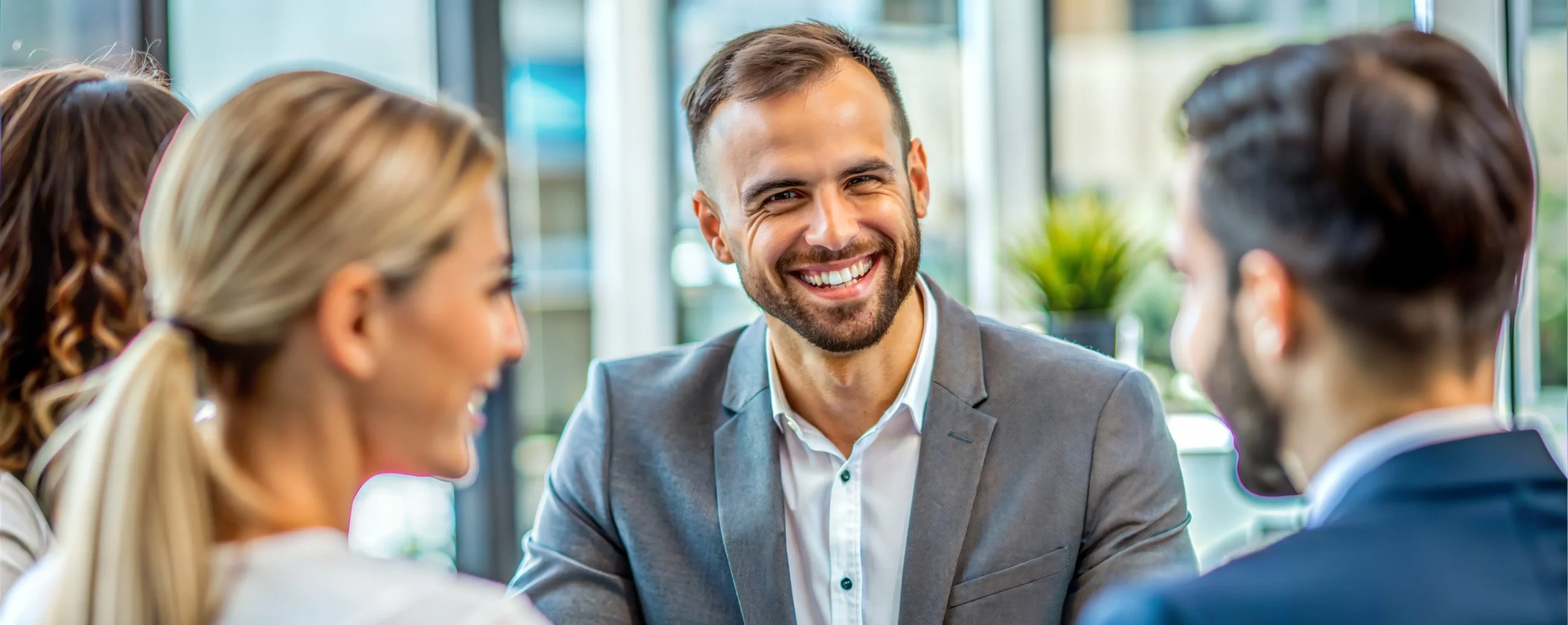 Smiling business professionals in a meeting, discussing insurance process outsourcing solutions.